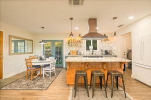 a kitchen with a large island and a table with stools at Bohemian Chic Cottage near Yosemite in Oakhurst