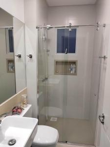 La salle de bains est pourvue d'une douche, de toilettes et d'un lavabo. dans l'établissement Apartamento luxo Meia Praia, à Itapema