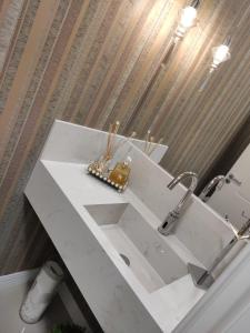 - un comptoir blanc dans la salle de bains pourvue d'un lavabo dans l'établissement Apartamento luxo Meia Praia, à Itapema