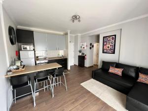 a living room with a black couch and a kitchen at Apartamento Barão in Amora