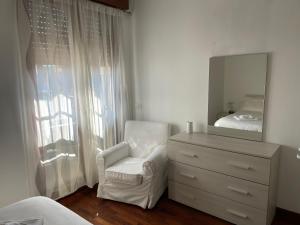 een slaapkamer met een dressoir, een stoel en een spiegel bij [Pvt Terrace] Connected To Duomo in Sesto San Giovanni