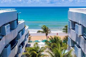 a view of the beach from between two buildings at Beira a mar Ponta Negra Beach, Lovely Flat Natal RN in Natal