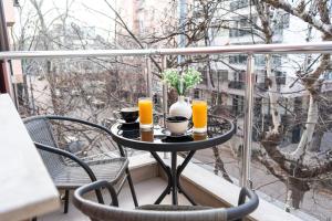 - une table avec deux verres de jus d'orange sur un balcon dans l'établissement Modern & Bright 1BD Apartment near Main Square, à Plovdiv