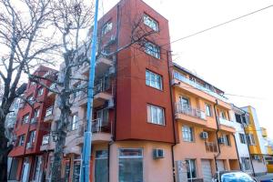 un bâtiment rouge avec une horloge sur son côté dans l'établissement Modern & Bright 1BD Apartment near Main Square, à Plovdiv