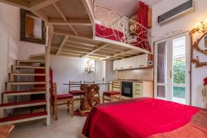 a large room with a red bed and a kitchen at MERLO 1 free park & wifi in Pisa