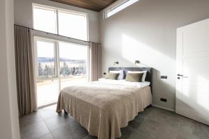 um quarto com uma cama e uma grande janela em Holt Villa em Reykholt
