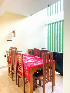 a dining room with a red table and chairs at Marathona Tourist Resort - Anuradhapura in Anuradhapura