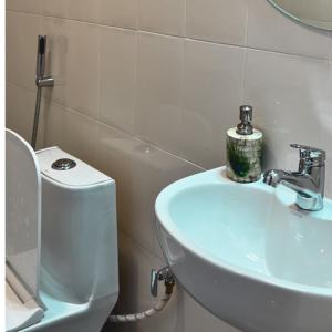 Iranyai Homestay في امفال: حمام مع حوض أبيض ومرحاض