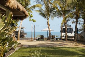 a house with palm trees and a van parked on the beach at Sunset Villas Palauig Zambales in Palauig