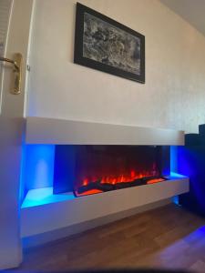 a living room with a fireplace with blue lights at Les cygnes de Criel-sur-Mer in Criel-sur-Mer