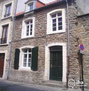 un antico edificio in pietra con finestre bianche e una porta di Le petit bonheur de la Haute a Boulogne-sur-Mer