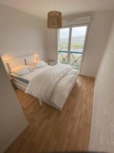 um quarto com uma cama e uma grande janela em Les cygnes de Criel-sur-Mer em Criel-sur-Mer