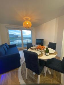 a dining room with a table and a blue couch at Les cygnes de Criel-sur-Mer in Criel-sur-Mer +41 photos