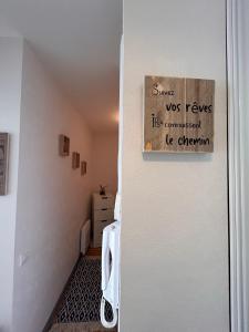 Una habitación con una puerta con un cartel. en Les cygnes de Criel-sur-Mer, en Criel-sur-Mer