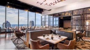 ダラスにあるMint House Dallas - Downtownのテーブルと椅子、大きな窓のあるレストラン