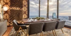 ダラスにあるMint House Dallas - Downtownのテーブルと椅子と大きな窓のあるダイニングルーム