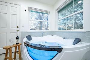 a bath tub in a bathroom with windows at Wooded Hills Mountain home with Hot tub, Jacuzzi, Game Room, Pool Table in Oakhurst