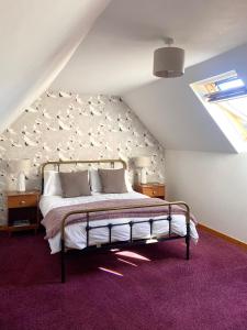 a bedroom with a large bed in a attic at Wee Silverburn in Whiting Bay