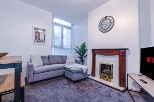 a living room with a couch and a fireplace at Spacious 4 Bed Home With Parking in Manchester