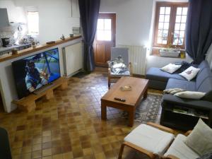 sala de estar con sofá y TV en Une maison dans le village, en Ribiers