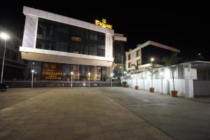 an empty parking lot in front of a building at night at Hotel G-Square - Shirdi in Shirdi