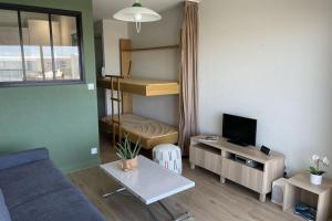 ein kleines Wohnzimmer mit einem Sofa und einem TV in der Unterkunft Pretty and bright studio with view on the harbor in Les Sables-dʼOlonne