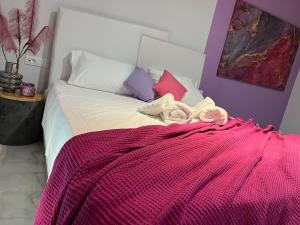 una camera da letto con un letto con una coperta rosa sopra di Longbeachvillas 2 Thesia beachfront villa a Makris Gialos