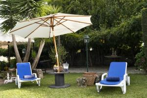 duas cadeiras e uma mesa com um guarda-sol em 5 bedrooms villa with private pool enclosed garden and wifi at Penafiel em Penafiel