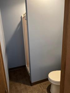 a bathroom with a toilet and a white wall at Best Budget Inn Owatonna in Owatonna