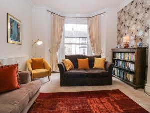 a living room with a couch and a book shelf at Flat 1 Kentholme in Grange Over Sands