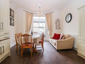 a dining room with a table and chairs and a couch at Flat 1 Kentholme in Grange Over Sands