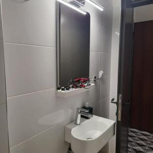 Baño blanco con lavabo y espejo en COSY APARTMENT IN VERIA, en Veria