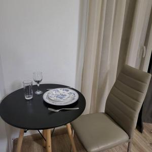 a table and a chair with a plate and glass at COSY APARTMENT IN VERIA in Veria