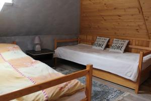 two twin beds in a room with wooden walls at Elena Apartaments in Sármellék