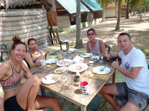 卡佩蹄尤的住宿－araliya villa，一群坐在桌子旁吃食物的人