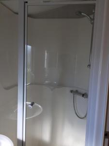 a shower with a glass door in a bathroom at Beside the Seaside, Pakefield Holiday Park, Arbor Lane, Pakefield, Lowestoft NR33 7BE in Pakefield