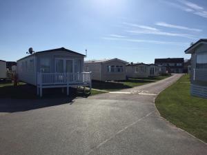 una fila de casas móviles en una carretera en Beside the Seaside, Pakefield Holiday Park, Arbor Lane, Pakefield, Lowestoft NR33 7BE, en Pakefield