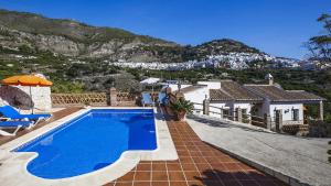 uma casa com piscina e uma montanha em Villa Francisco em Frigiliana