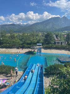 - une grande piscine avec des personnes à l'eau dans l'établissement Apartament Czarny Staw, à Zakopane