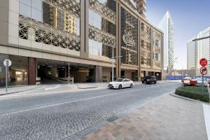 a white car driving down a street in front of a building at Elite Downtown Residences - Paradise View in Dubai
