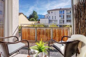 uma varanda com 2 cadeiras e uma cerca em Exklusive Familienappartments Zugspitze em Garmisch-Partenkirchen