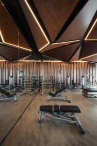 un gimnasio con varias filas de equipos de ejercicio y espejos en Edge Central Pattaya #188, en Pattaya central