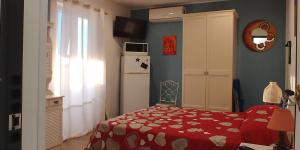 - une chambre avec un lit rouge et un réfrigérateur dans l'établissement La Rosa dei Venti, à Isola delle Femmine