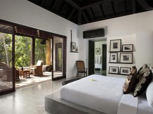 a bedroom with a large bed and a patio at Villa Hana in Canggu