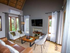 a living room with a couch and chairs and a table at Ingwe Bush Lodge in Hoedspruit
