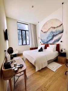 een slaapkamer met een bed en een tafel en een schilderij bij AUX DUCS DE SIENNE in Montagne