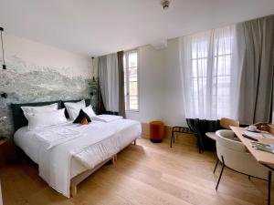 1 dormitorio con 1 cama blanca grande y escritorio en AUX DUCS DE SIENNE, en Montagne