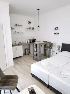 a white living room with a white couch and a table at Vajda Apartments in Novi Sad