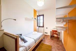 Kleines Zimmer mit einem Bett und einem Schreibtisch. in der Unterkunft Homiday - Tuscany House - Parcheggio e Giardino Privato in Pisa