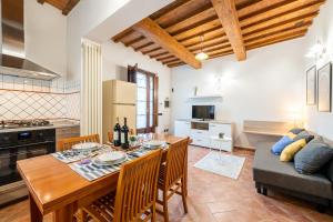 比薩的住宿－Homiday - Tuscany House - Parcheggio e Giardino Privato，厨房以及带桌子和沙发的客厅。